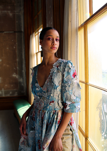 Photo of woman in a blue dress posing indoors, by a tall window