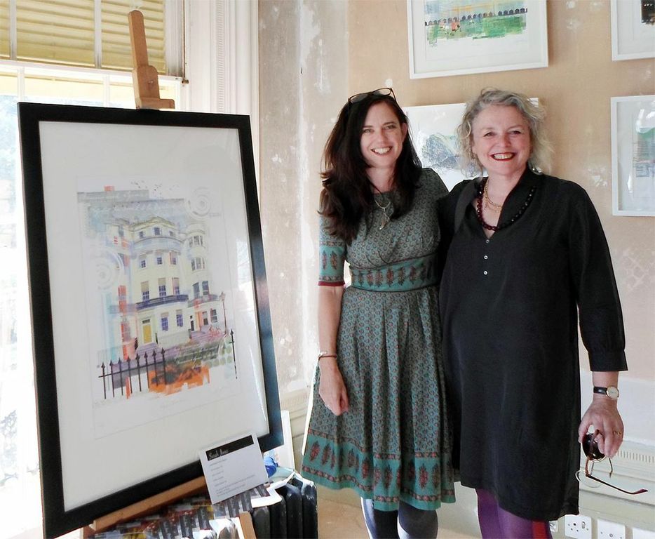 Artist Sarah Jones with volunteer Fiona Walsh standing next Sarah's new print of the Regency Town House
