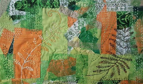 Hand stitched work depicting fern-like forms against a patchwork background of orange and green fabrics