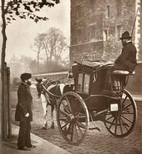 Photo of a driver in his Hansom Cab in London 1877. He's talking to a potential passenger on the roadside