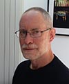 Photo of volunteer Kevin Wilsher, with short white beard and wearing a black jumper and spectacles
