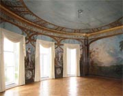 Interior of grand room showing painted scenes on walls and ceiling