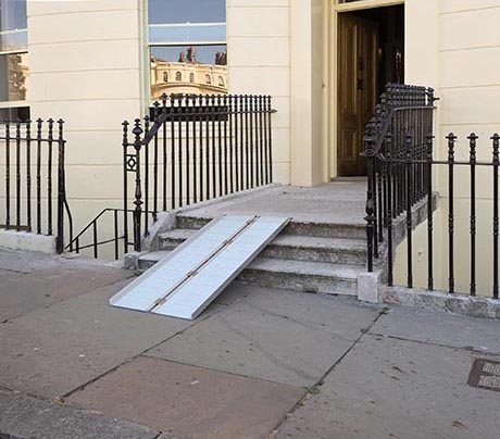 Photo of exterior of a Regency house showing an access ramp deployed on three stone steps