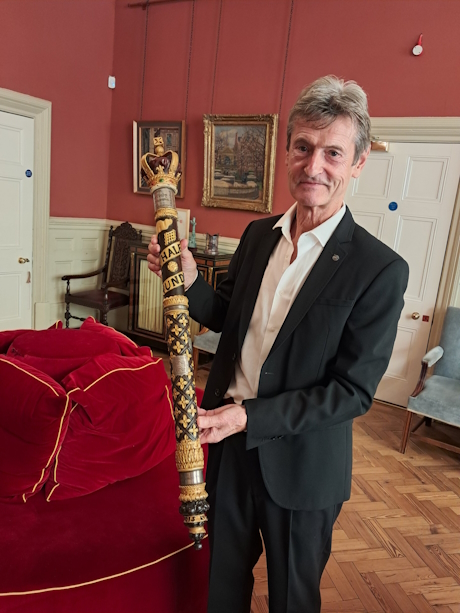 A colour photo of a man holding a large stave
