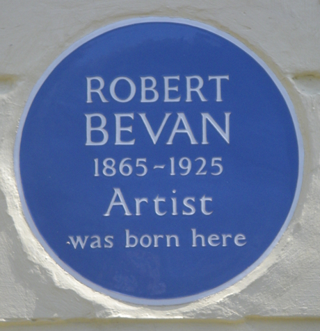 A colour photo of a blue commemorative plaque on a building